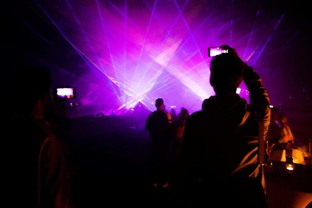 open air location berlin Lila lasershow wird aufgenommen von Mann mit Handy